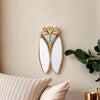 A golden cicada hanging ornament made of resin displayed on a light beige wall.