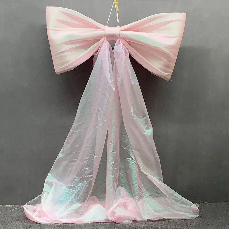 Pink satin bow with long sheer tulle drape used for event decoration