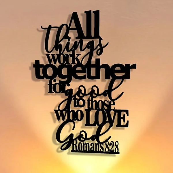 Black metal wall art featuring the Bible verse Romans 8:28 in elegant script.
