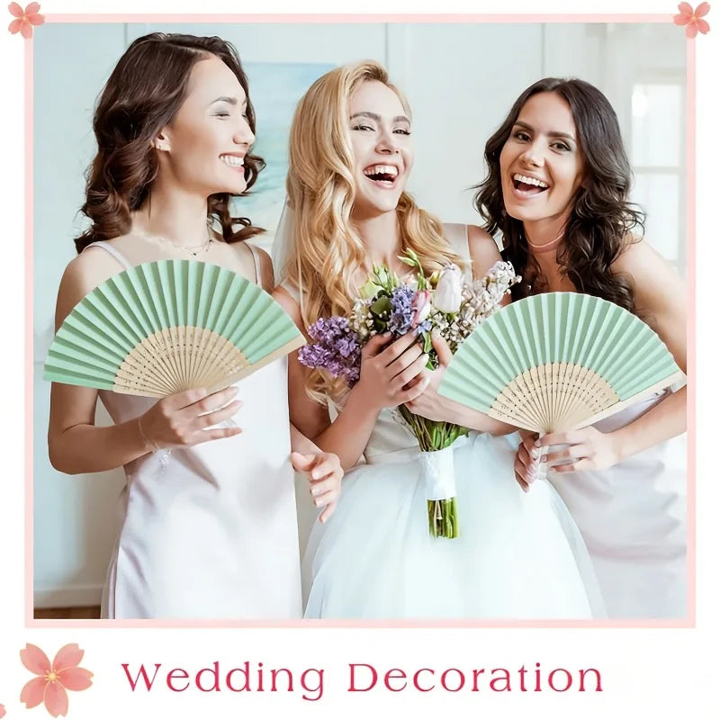 Three brides smiling while holding and displaying green and beige folding wedding fans.