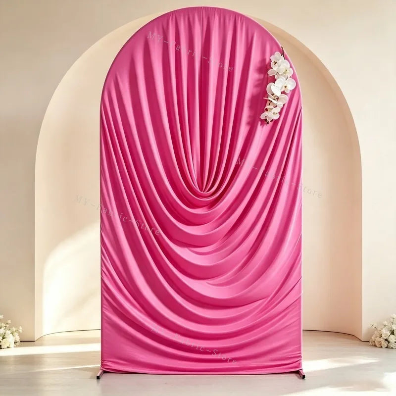 A vibrant pink stretchy spandex arch cover draped in soft folds, used as a backdrop for weddings and events.
