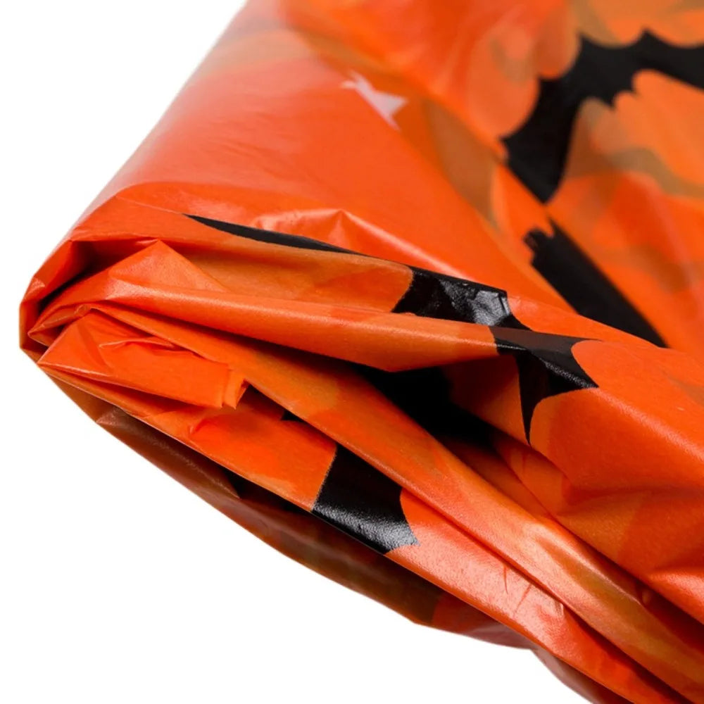 Orange Halloween tablecloth featuring a print of pumpkins, spider webs, and bats.