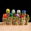 A collection of colorful natural crystals, including yellow, green, purple, and blue stones, set in brass tree-shaped chimes.
