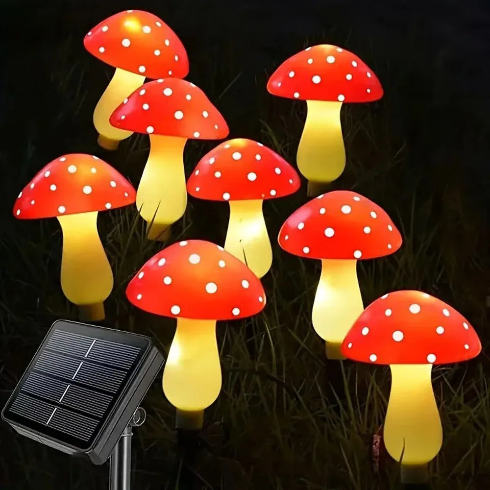 Set of six solar mushroom garden lights with red caps and yellow glow illuminating grass.