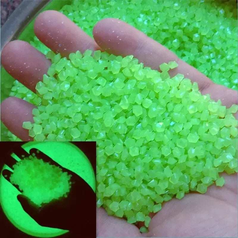 A hand holds a pile of bright, luminous green glow-in-the-dark pebbles.