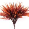 A bouquet of artificial fall eucalyptus and flower stems in shades of orange and brown.