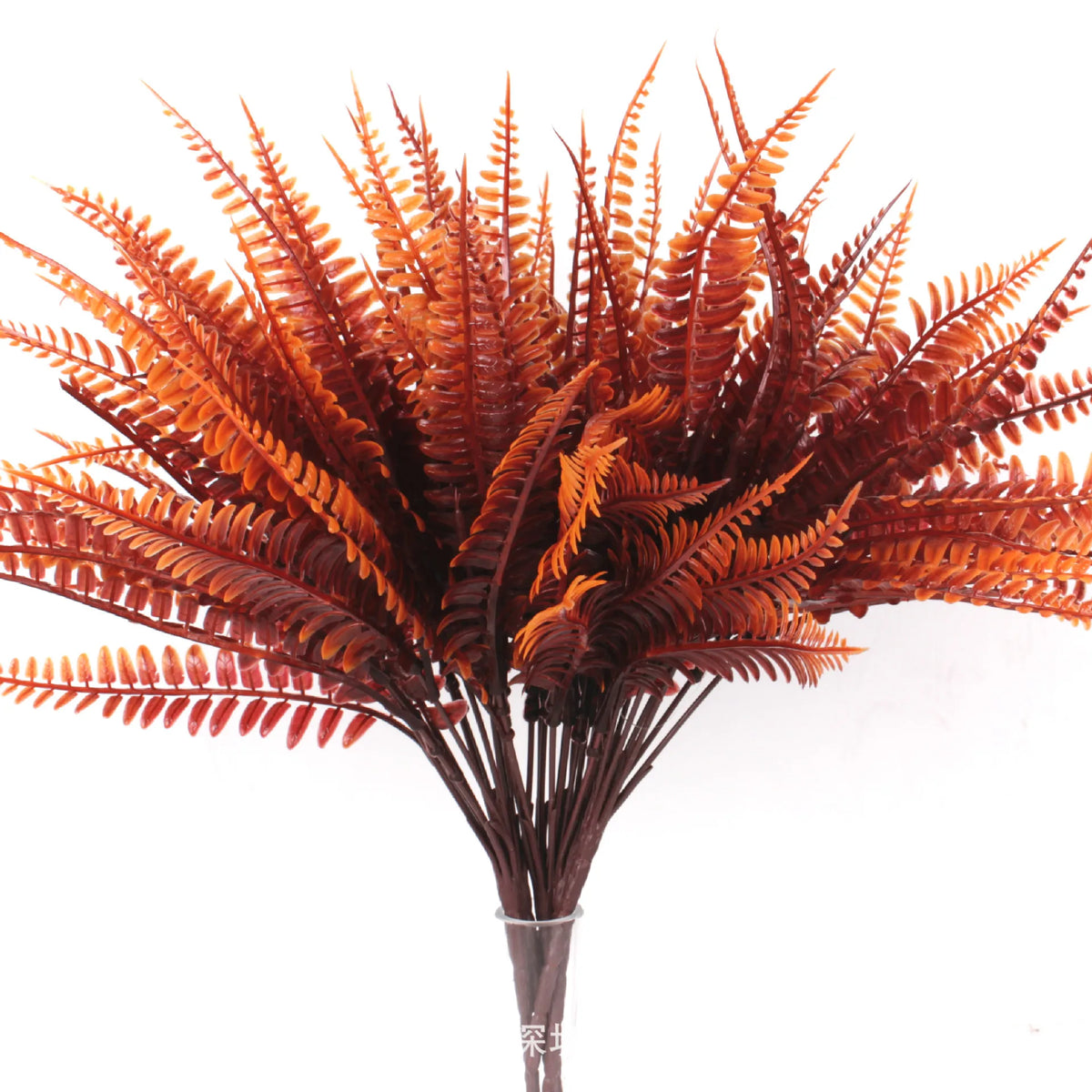 A bouquet of artificial fall eucalyptus and flower stems in shades of orange and brown.