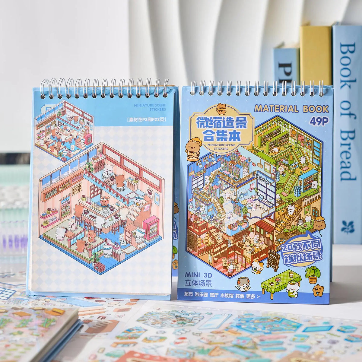 A blue spiral notebook titled Material Book featuring miniature scene stickers for kids