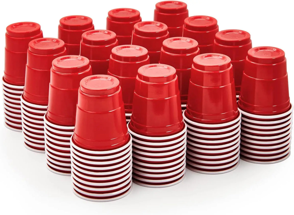 A stack of fifty red disposable shot glasses with white striped bases.