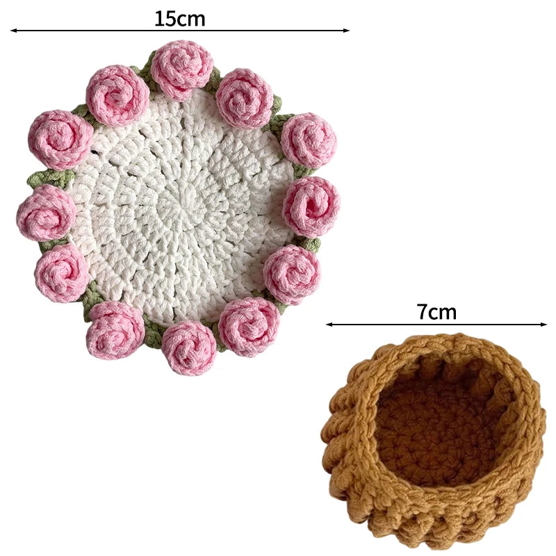 Hand-crocheted pink rose flower coasters with a textured white center and brown base.