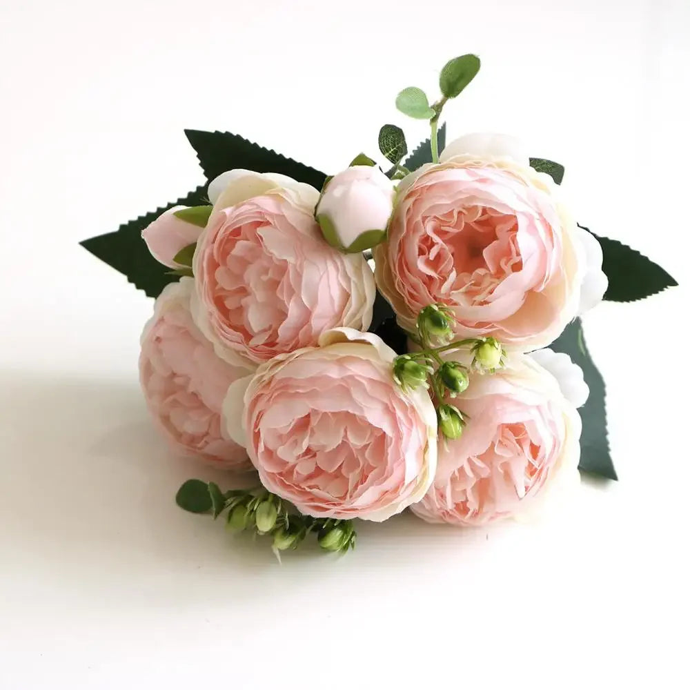 A bouquet of pink and white silk rose and peony artificial flowers with green leaves.