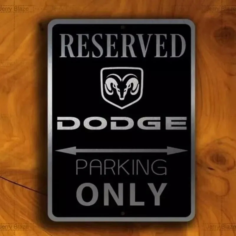 A black metal sign with the word RESERVED, a Dodge emblem, and text indicating parking only.