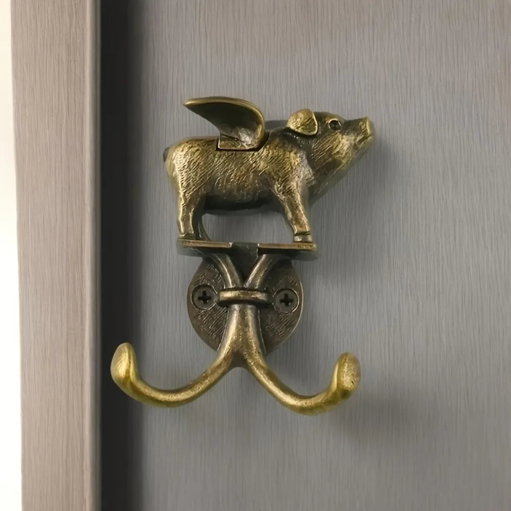 A decorative metal wall hook shaped like a fox head mounted on a curved brass hook.