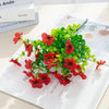 A bouquet of red and green silk eucalyptus and violet artificial flowers on a white background.