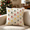 A cream-colored knitted pillow cover featuring a repeating pattern of small red, green, and yellow Christmas tree shapes.