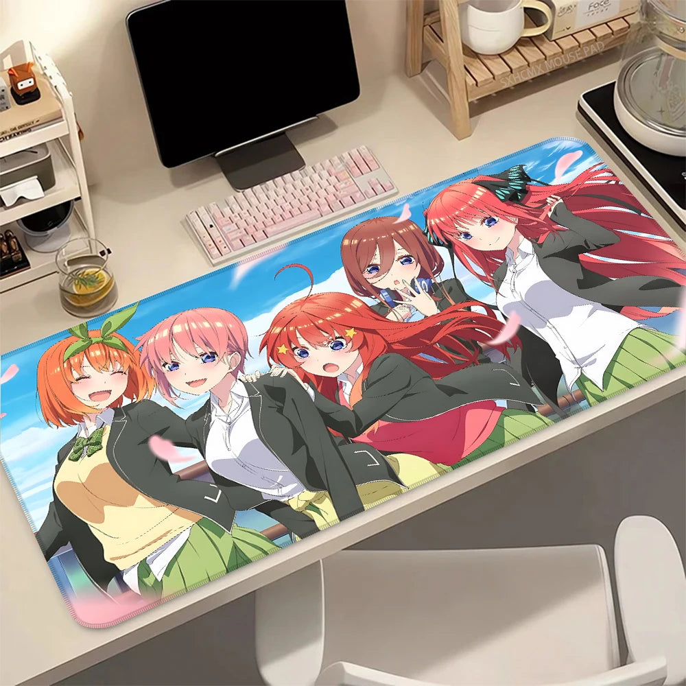 A desk mat featuring the Quintessential Quintuplets anime characters with a non-slip rubber base.