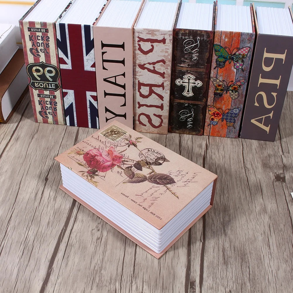 A stack of vintage-style dictionary lock boxes with various text and colors, next to an open leather-bound book.