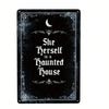 A black metal tin sign featuring a crescent moon and gothic script that reads She Herself is a Haunted House