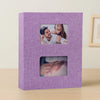 A purple linen-cover photo album with two framed photos inside.