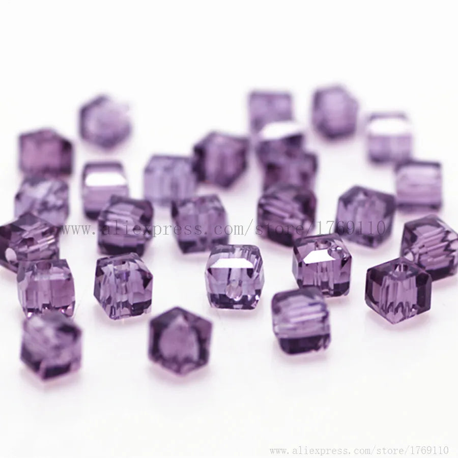 A collection of purple square cut glass crystal beads scattered on a white background.