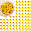A hand holds a large collection of yellow resin mini mushroom figurines.