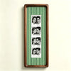 A vertical photo strip frame with a walnut wood border and green and white vertical stripes, displaying several portrait phot