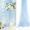 White sheer tulle draping fabric used as a wedding arch backdrop with white roses and fairy lights.