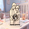 A white silhouette of a mother and baby embracing, with a circular ultrasound photo inside, on a white base.