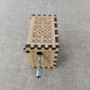 Antique carved wooden music box with decorative patterns and a metal hinge