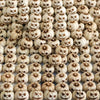 Gros plan de nombreuses petites citrouilles en résine sculptées dans différentes nuances de beige et de brun pour la décorati