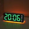 A digital alarm clock displaying 20:06 with a bright green LED display and an orange ambient light.