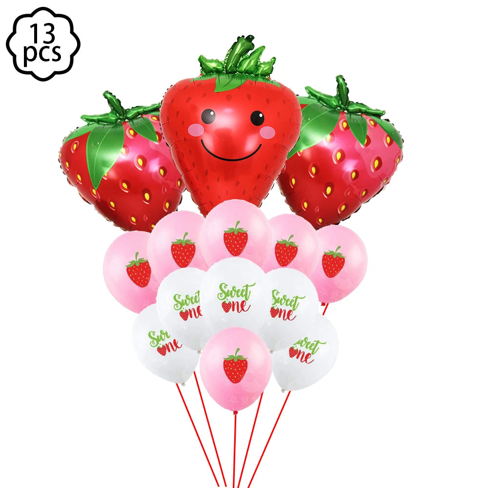 A kit of strawberry-themed party supplies including a large strawberry decoration and pink plates.