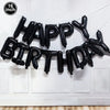 Black foil balloon letters spelling out Happy Birthday strung across a white door frame