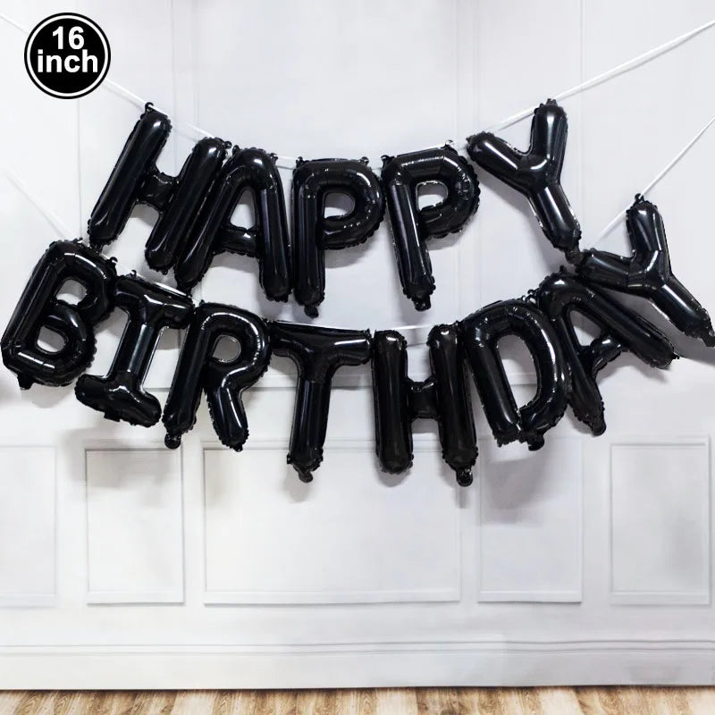 Black foil balloon letters spelling out Happy Birthday strung across a white door frame