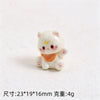 A small white resin cat keychain with pink accents and an orange collar.