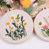Punch needle embroidery kit featuring a daisy and sunflower design on stamped cloth with yarn tools