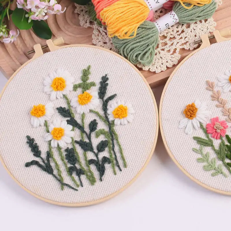 Punch needle embroidery kit featuring a daisy and sunflower design on stamped cloth with yarn tools