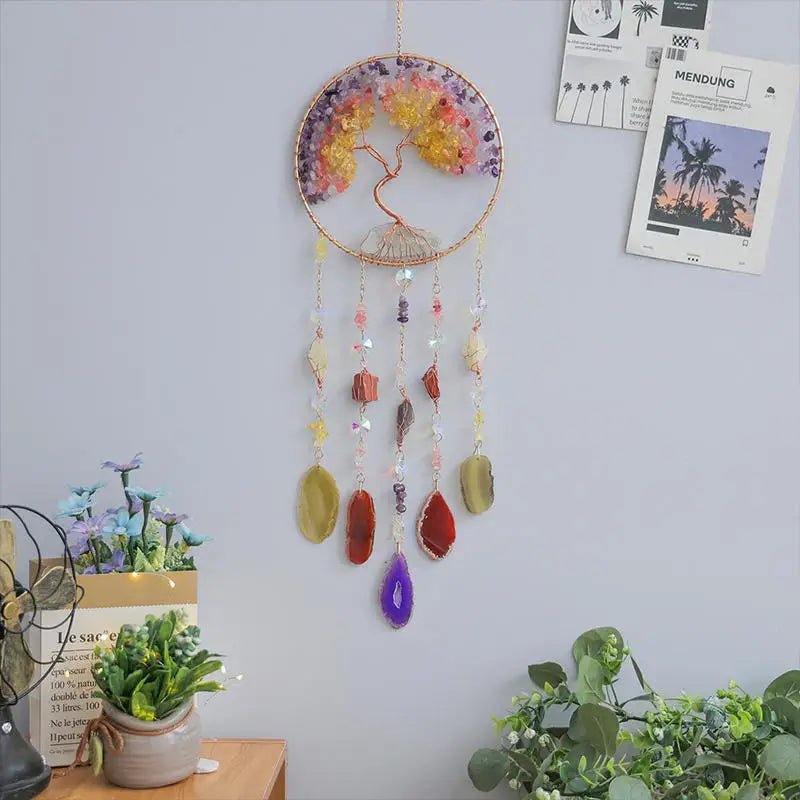 A crystal tree of life sun catcher wall decor featuring a circular frame with colorful petals and hanging crystals.