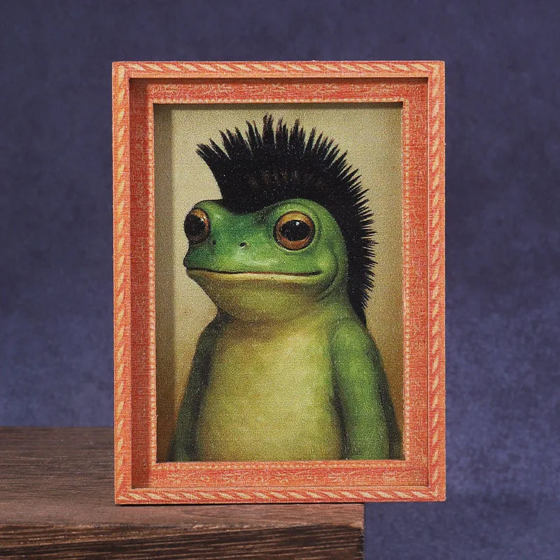 A framed picture of a green frog with black spiky hair inside a wooden frame.