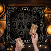Hands hold a square Celtic cross altar cloth for tarot and divination on a dark background.