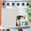 A beige linen photo album with self-adhesive pages is displayed next to a potted plant.