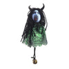 A scarecrow witch ornament featuring a black, hairy face with glowing blue eyes and a green netting dress.