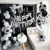 A large arrangement of black and white latex football shaped balloons for a birthday party decoration.
