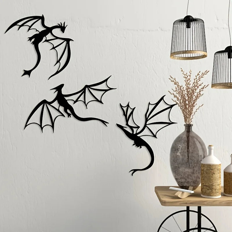 A set of three black dragon metal wall art panels hanging on a white wall next to decorative light fixtures.