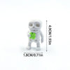A white skull figurine with a green heart shape attached, shown against a white background.