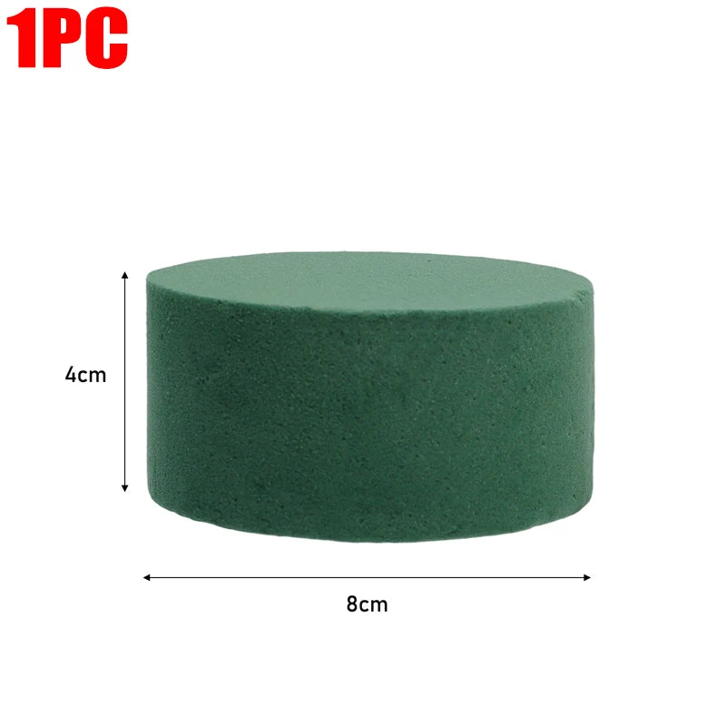 One piece of round, dark green floral foam block measuring 4cm high and 8cm wide.