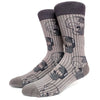 A pair of dark gray crew socks featuring repeating skull, alien, and tiger prints.