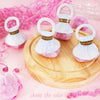 A wooden plate holds pink and white confetti streamer poppers with red and green accents.