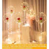 Clear bubble balloons with red roses and fairy lights displayed on a white pedestal.