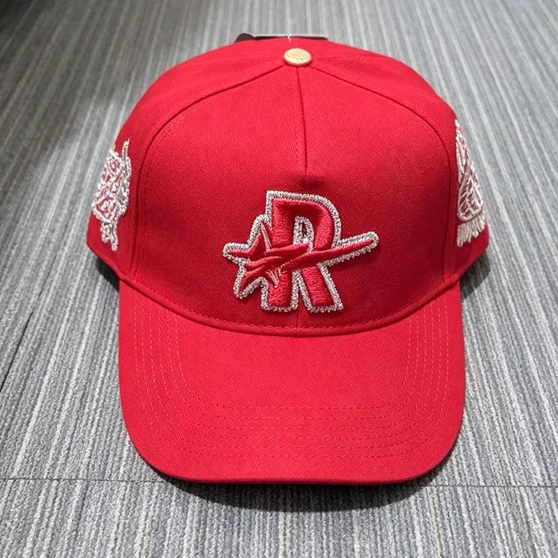 A red baseball cap embroidered with a silver star logo and matching embroidery on the sides.